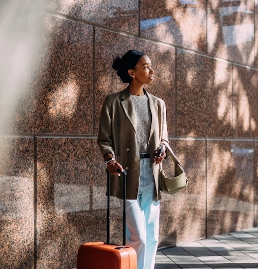 woman waiting for something with her luggage Turquoise marble background Dr Olatomide (Tomi) Famalusi | Élevé Plastic Surgery Plastic Surgery Atlanta