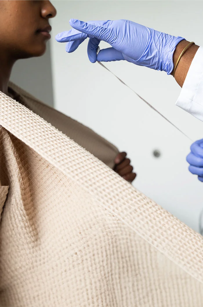 A woman having her breasts measured by a dr - Breast Lift at Eleve Plastic Surgery