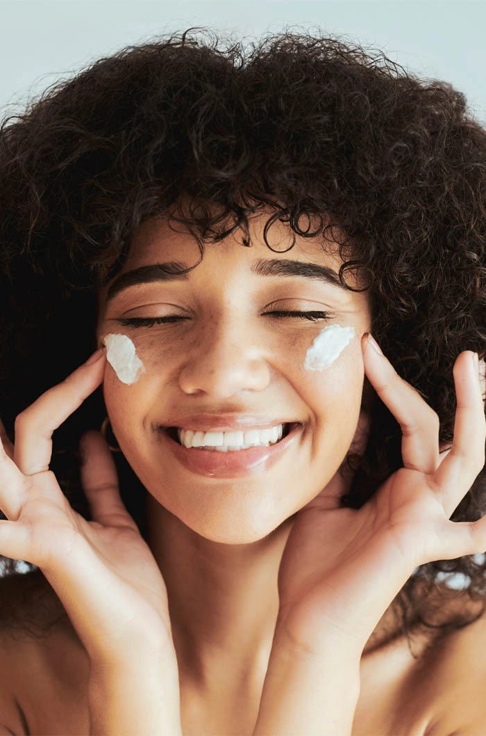girl putting on facial cream looking happy eleve plastic surgery